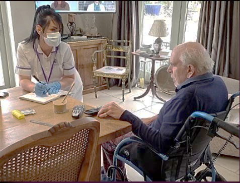 Man speaking with carer over a table: Respite Care
